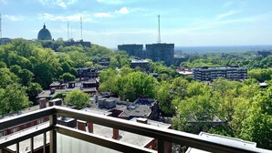 En stadsbild med byggnader, träd och en klar himmel.