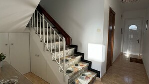 Una escalera de diseño singular que lleva a un rellano con una lámpara.