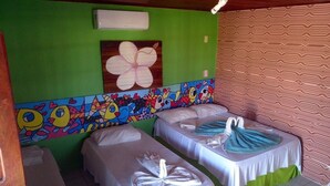 Una habitación con dos camas individuales, un mural en la pared y una cortina estampada.