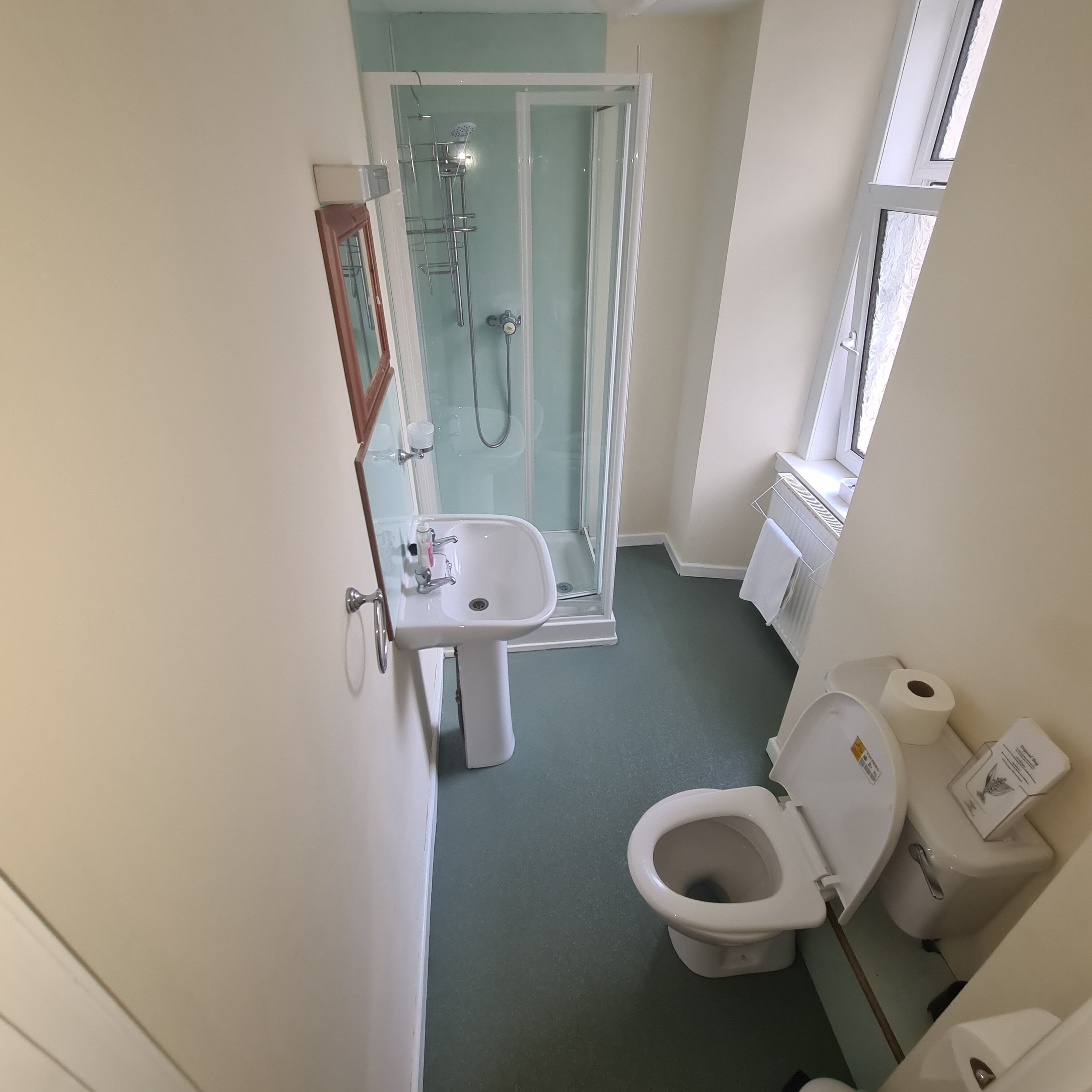 Un bagno compatto con servizi igienici, lavandino e cabina doccia in vetro.