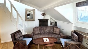 Ein Wohnzimmer mit einer Sofagarnitur, zwei Sesseln, einem Couchtisch und einem Kamin.