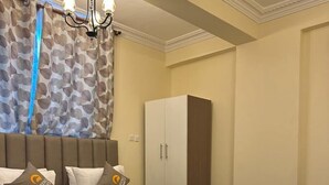 Ein modernes Hotelzimmer mit einem großen Bett, einem Kleiderschrank und einer Chandelier.