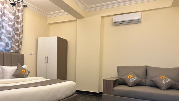 Ein Hotelzimmer mit Bett, einer Couch, einem Kleiderschrank und einer Klimaanlage.