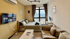 A hotel room with a bed, a sofa, a TV mounted on the wall, a ceiling fan, and a window with a city view. - Neu Suites by Moonlight  (Kuala Lumpur)