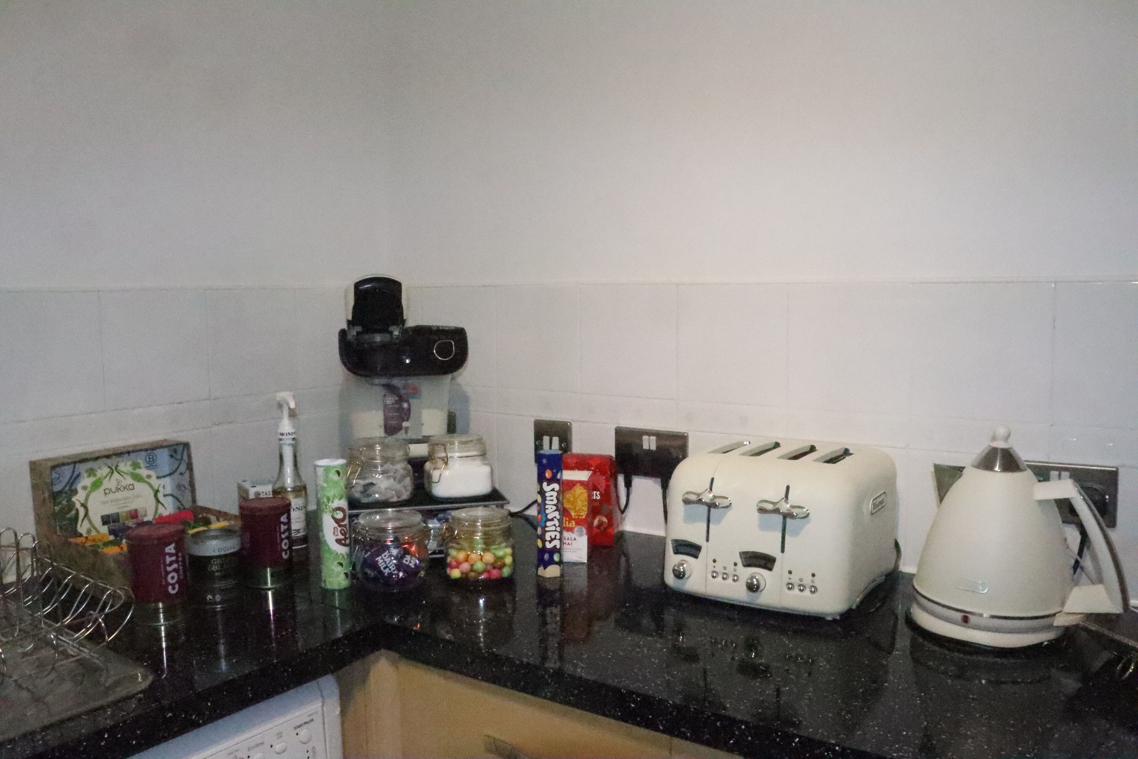 A kitchen counter with a coffee maker, toaster, and various food items.