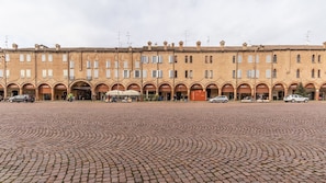 A historic building with a courtyard paved with cobblestones. - Dimora Piazza Martiri | A/C WiFi FS Station-Center (Carpi)