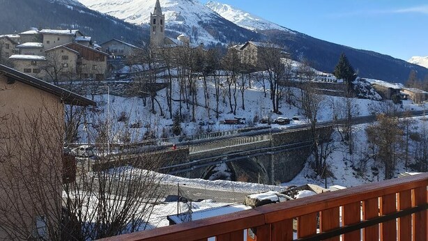 A snow-covered mountain with a church and buildings in the foreground.