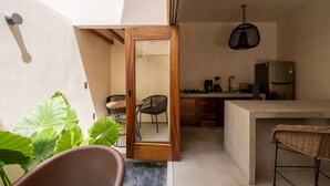 Una cocina moderna con una isla grande, un comedor con una silla y una lámpara colgante.