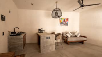 Una cocina moderna con barra, sofá y mesa de comedor.
