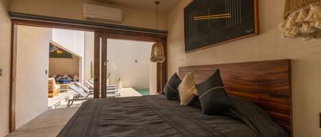 Un dormitorio con una cama grande, cabecera de madera y vistas a un balcón.