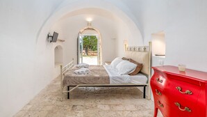Une chambre à coucher avec un lit, une commode rouge et un téléviseur fixé au mur.