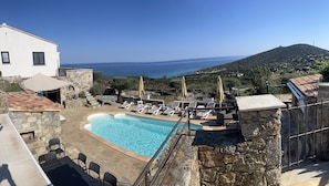 A pool area with lounge chairs and a view of the sea. - Villa Ghjunchitu - Proche de l'ile Rousse (Corbara)