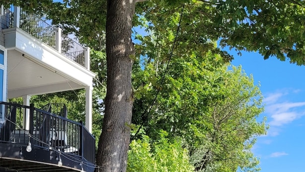 Una propiedad frente al agua con terraza de madera, asientos exteriores y vista al mar.