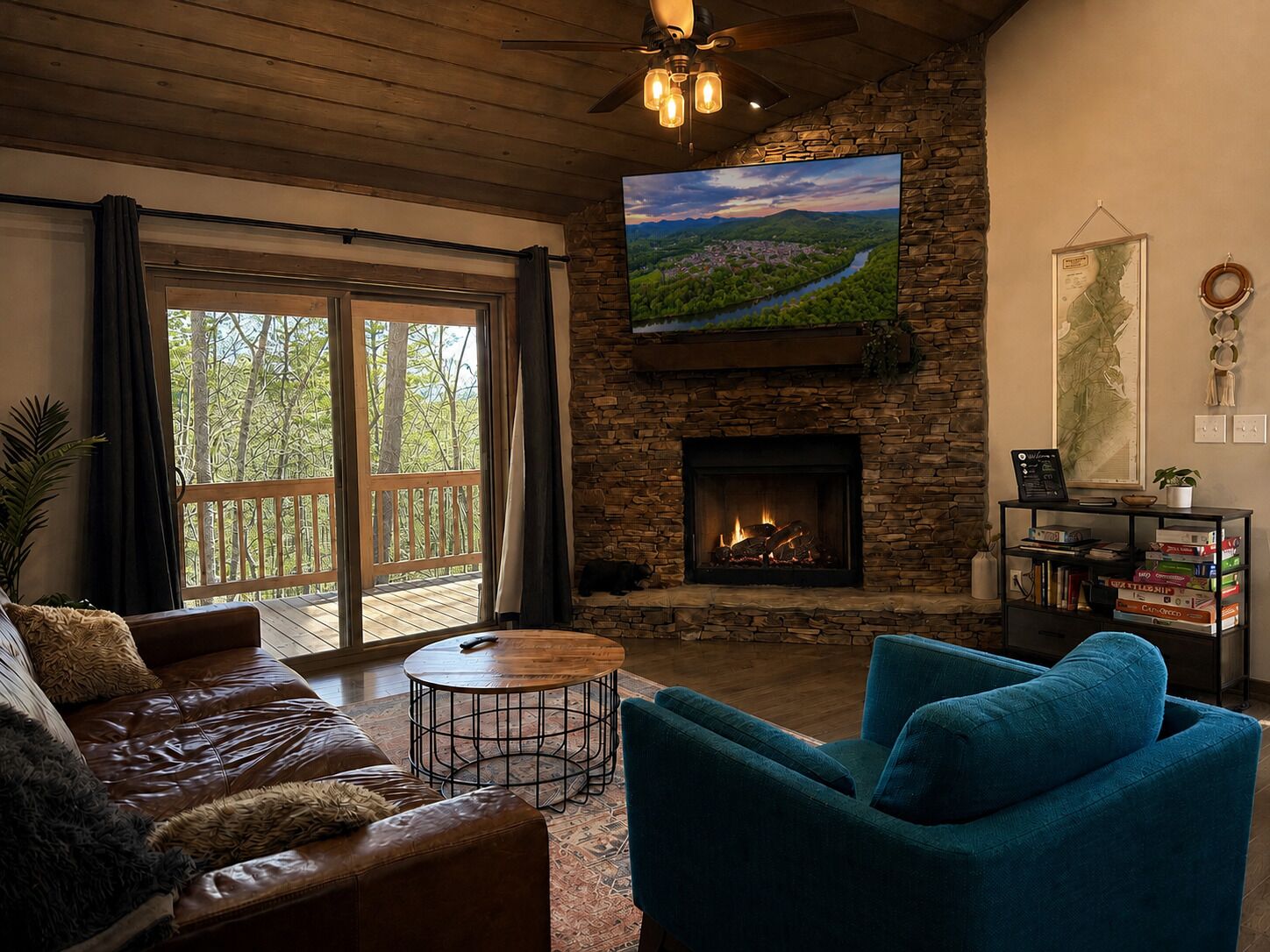 Cozy mountain-style living room with stone fireplace and wooded deck