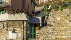 A stone building with a green gate, a small balcony with plants, and a sign reading "VIA E. SOLIMANO". - Apartment in Sori with 3 bedrooms sleeps 6 (Sori)