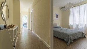 A bedroom with a bed, a desk, and a chair. There is a hallway leading to a bathroom. - Apartment in Sori with 3 bedrooms sleeps 6 (Sori)