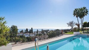 A swimming pool with a view of the sea, surrounded by greenery and a metal fence. - Torreblanca with pool by Costarentals - Ref 63 (Fuengirola)