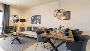 A modern dining area with a wooden table, black chairs, and a minimalist design. - La Cala de Mijas Modern Flat with Pool - ref 240 (Las Lagunas de Mijas)