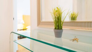 Ein modernes Badezimmer mit Glastrennwand, einem Blumentopf und einem Schlüsselsatz auf der Trennwand.