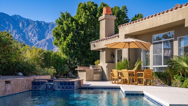 A pool with a patio area, outdoor furniture, and a mountain backdrop. - The Desert Flower, designer home in gated community/ private pool and jacuzzi. (Palm Springs)