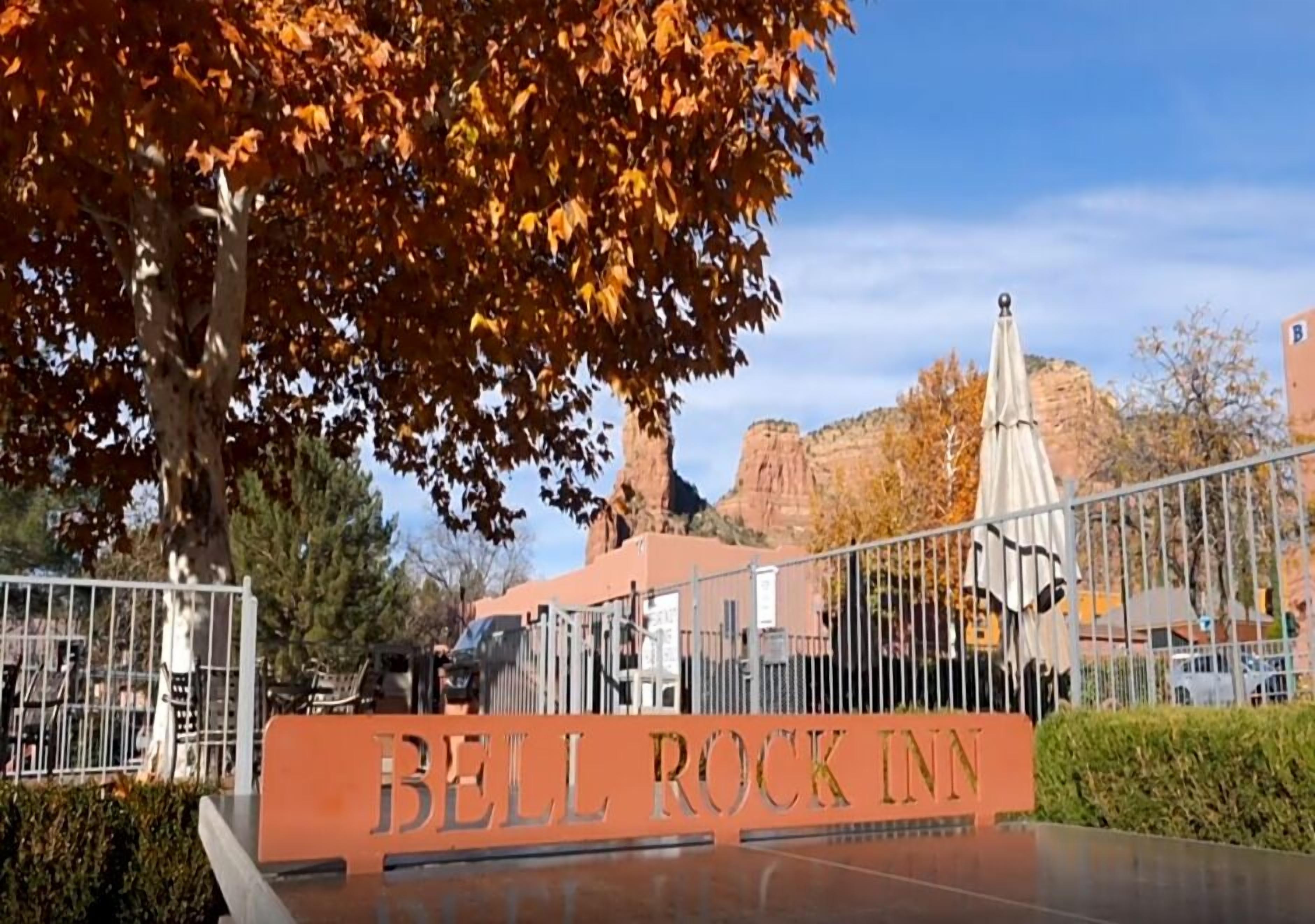 Señal del Bell Rock Inn con una vista despejada del paisaje circundante, que incluye árboles y formaciones rocosas a lo lejos.