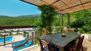 A covered outdoor area with a pool, wooden furniture, and a view of green hills. - Villa Eugenia (Kvarner - Mošćenička Draga) (Mošćenička Draga)