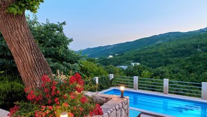 A swimming pool with stone walls and a view of a green landscape. - Villa Eugenia (Kvarner - Mošćenička Draga) (Mošćenička Draga)