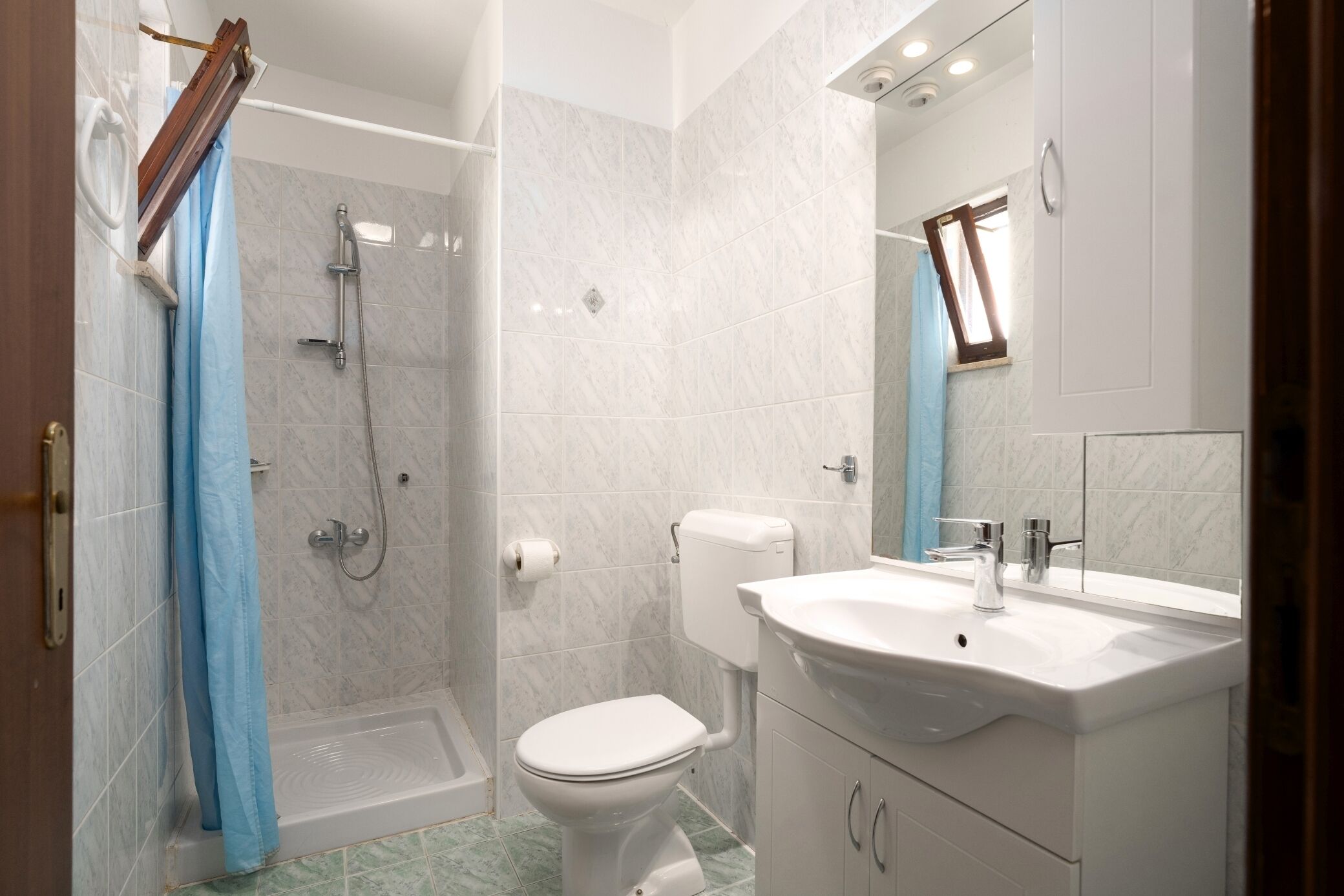 Un baño con ducha, inodoro y lavamanos.