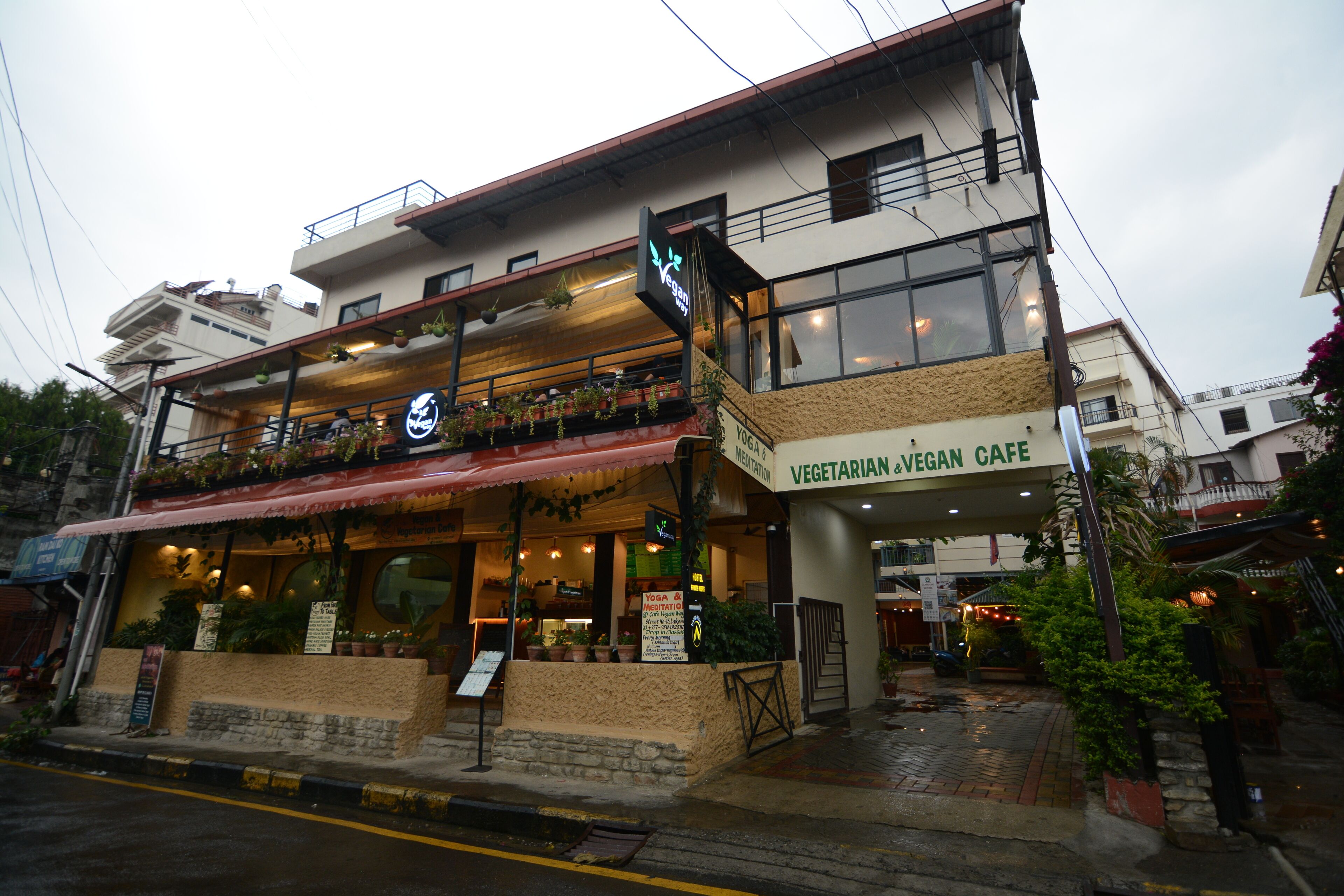 Un edificio de dos pisos con un letrero para un café vegetariano y vegano.