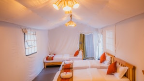 A room with two beds, a hanging light fixture, and a window with curtains. - Kalash Parkaze and Tent Inn (Pokhara)