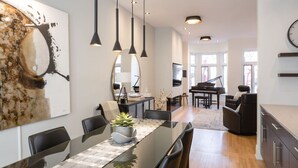 A modern kitchen with a dining area, a piano, and a large mirror. - Villa Montcalm: Prestige & Confort au Vieux-québec (Québec)