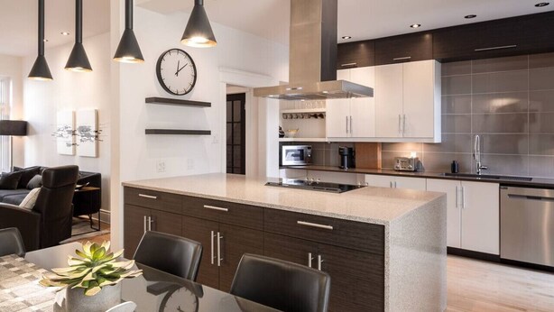 A modern kitchen with a central island, stainless steel appliances, and pendant lighting. - Villa Montcalm: Prestige & Confort au Vieux-québec (Québec)