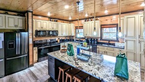A modern kitchen with wooden cabinets, stainless steel appliances, and a granite countertop.