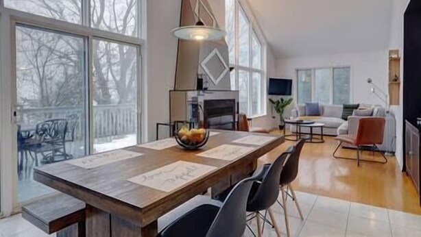 Amplia sala de estar con un gran comedor, muebles modernos y grandes ventanales que ofrecen vistas al exterior.