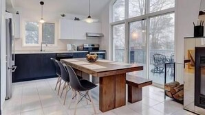 Una cocina moderna con una isla grande, iluminación colgante y vistas al exterior.