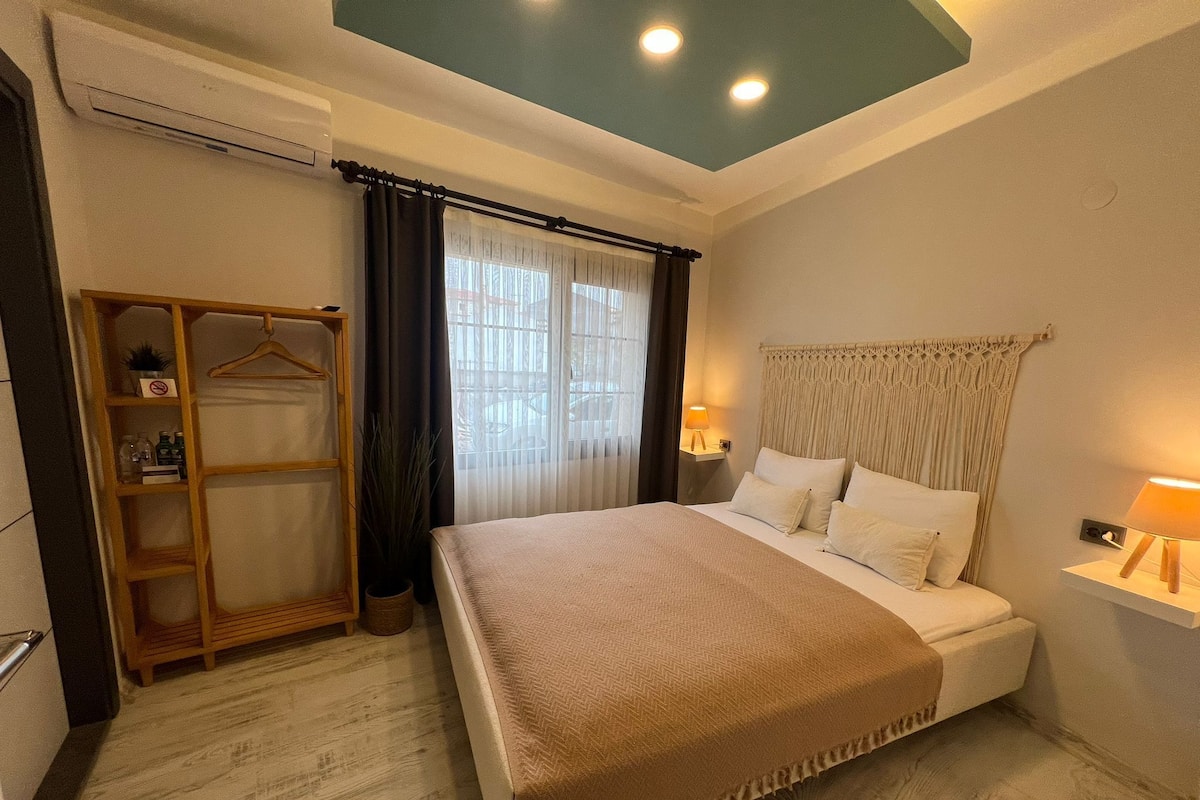 Una habitación de hotel con cama, lámparas de noche, armario y luz en el techo.