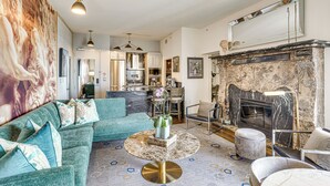 A modern living room with a sectional sofa, a round coffee table, and a fireplace. - Luxe Long Beach Condo w/ Pool: 1 Mi to Shoreline! (Long Beach)