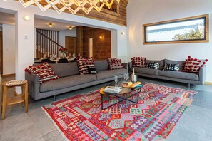 A modern living room with two sofas, a coffee table, and a colorful rug. - Chalet Gloribel, ski, views, Chamonix All Year (Chamonix)