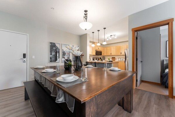 A modern kitchen with a central island, pendant lighting, and wooden cabinets.