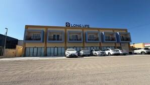 Ein mehrstöckiges Gebäude mit Balkonen und einem Schild, auf dem 'LONG LIFE' steht.