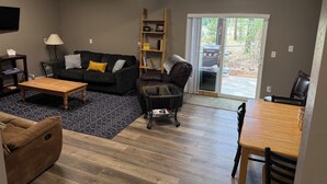 A modern living room with a sofa, coffee table, and a dining area. - Munds Park - Beautiful Munds Park Suite for Rent. Newly built! (Sedona)