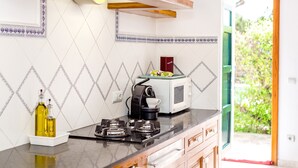 A kitchen with a microwave, gas stove, and a coffee maker.