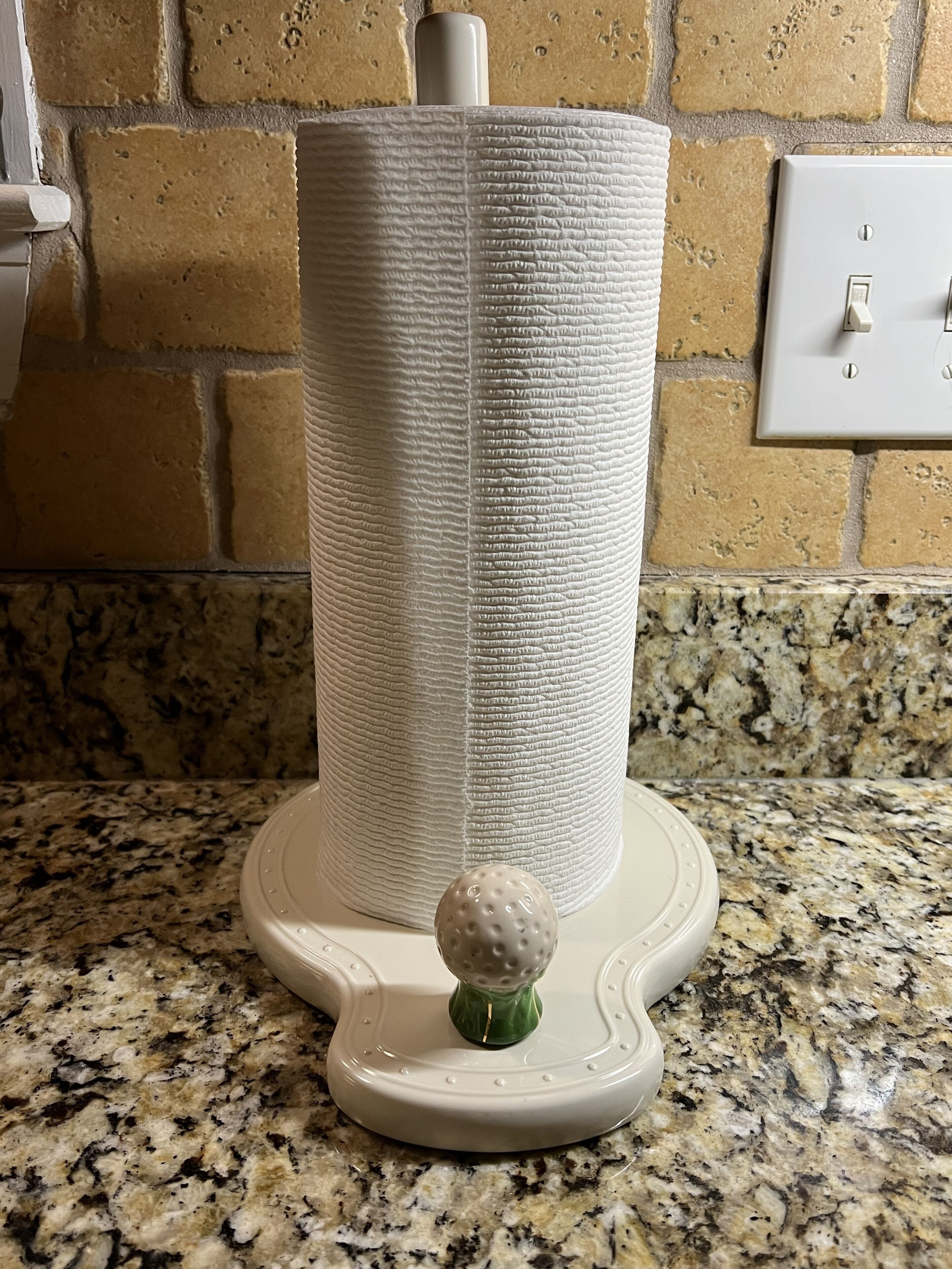Un arbre à chat doté d’une surface texturée et d’une petite balle fixée à sa base, placé sur un comptoir en granit.