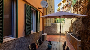 Une terrasse extérieure avec une table, des chaises et une antenne parabolique.