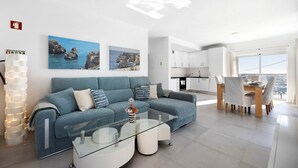 Una sala de estar moderna con un sofá, una mesa de centro y una obra de arte en la pared.