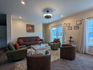 A living room with a brown sofa, two armchairs, a coffee table, and a ceiling fan. - Spacious Entire Home walking distance to Village (Ellicottville)