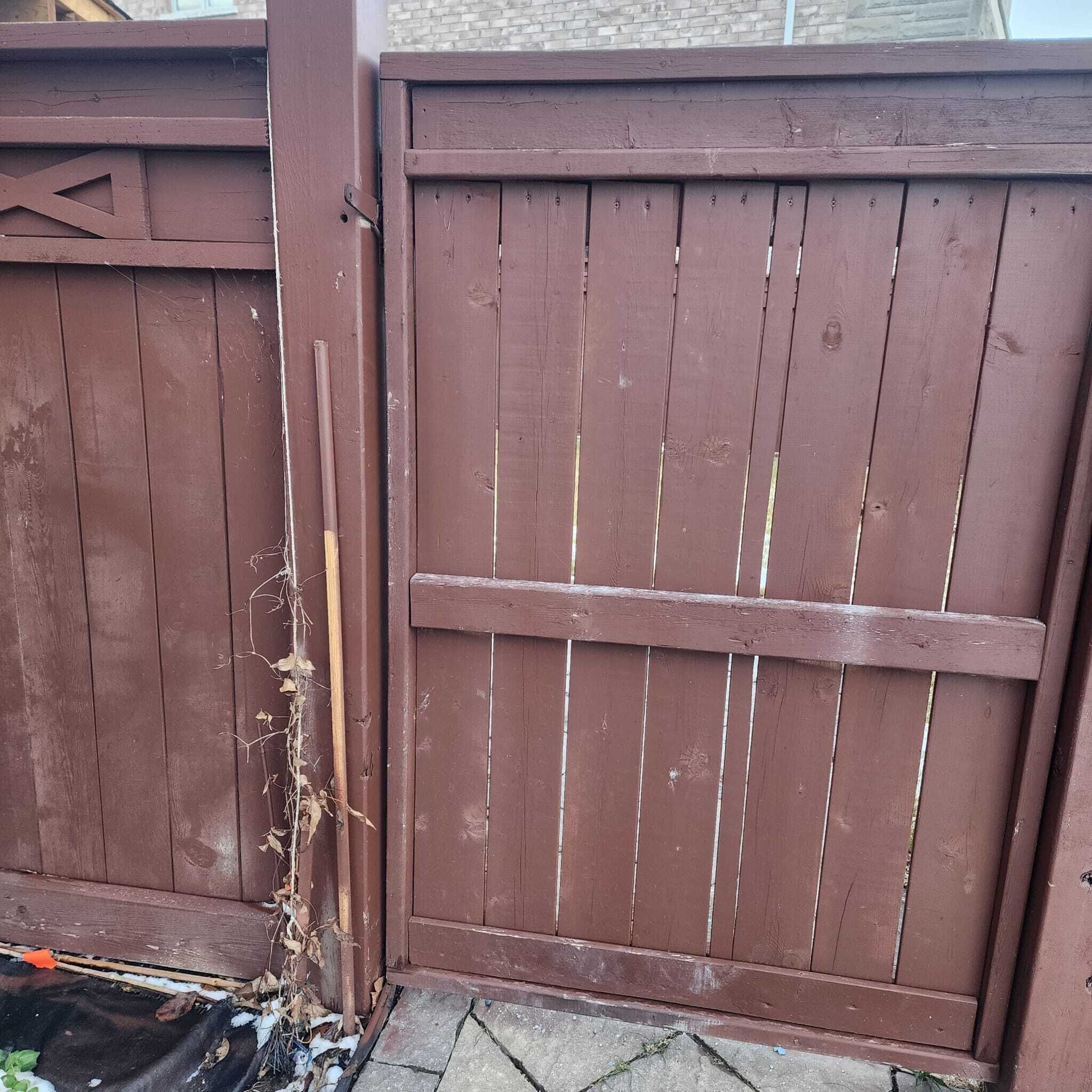 Een houten poort met een metalen grendel.