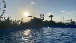 Una piscina con una noria al fondo.