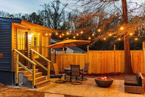 A backyard with a wooden deck, outdoor seating, a fire pit, and string lights. - The Golf Mode Abode- A Putter`s Paradise (Augusta)
