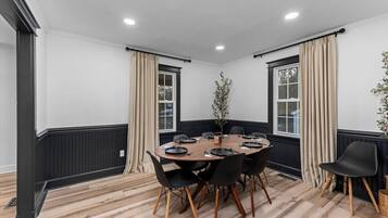 A conference room with a round table, black chairs, and beige curtains.